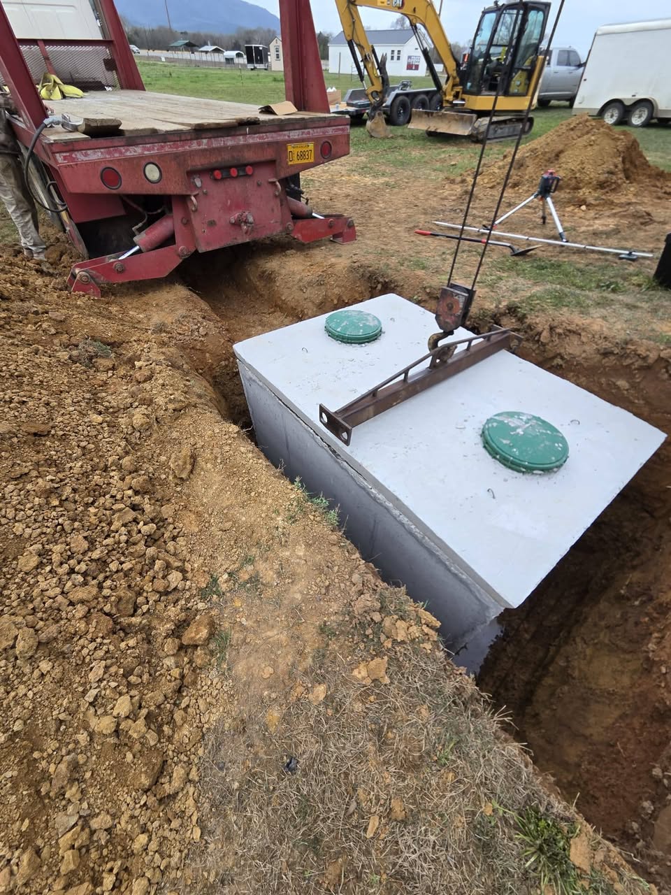 Concrete septic tank being set into an excavated hole